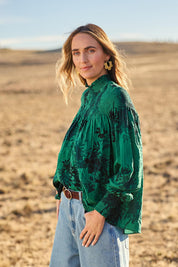 Model Tegan wearing size 10 of the Romance In The Air Blouse in colour Emerald (Green), from the front, showing the whole outfit