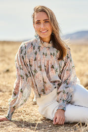 Model Tegan wearing size 10 of the Romance In The Air Blouse in colour Skyfleur (Blue), from the front, showing the whole outfit