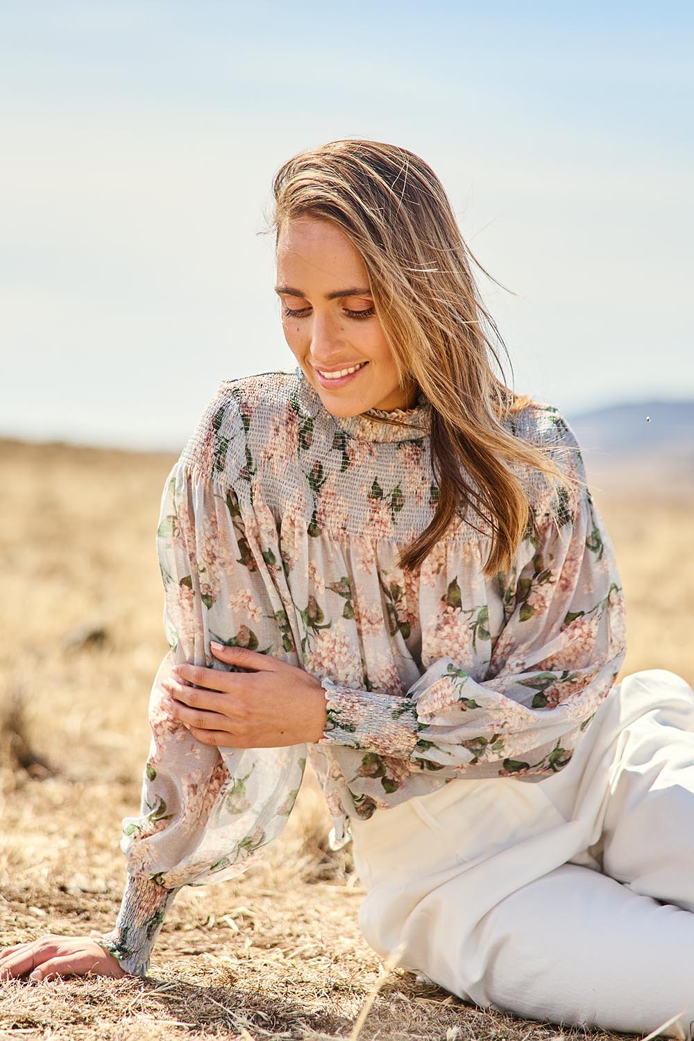 Model Tegan wearing size 10 of the Romance In The Air Blouse in colour Skyfleur (Blue), from the front, showing the whole outfit