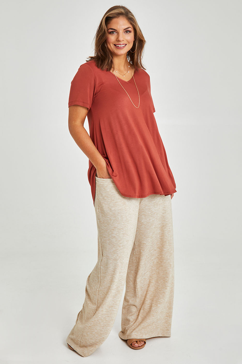 Model Monique wearing size 14 of the Softly Swinging Bamboo Tee in colour Clay (Red), from the front, showing the whole outfit