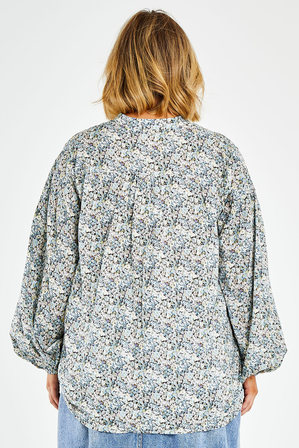 Model Jess wearing size 14 of the You And Me Cotton Floral Blouse in colour Skyfleur (Blue), from the back