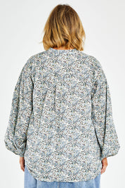 Model Jess wearing size 14 of the You And Me Cotton Floral Blouse in colour Skyfleur (Blue), from the back