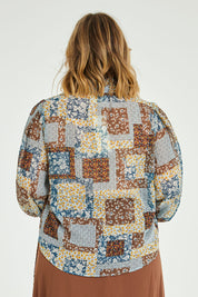 Model Jess wearing size 14 of the Not A Patch On You Blouse in colour Tealpatch (Blue), from the back