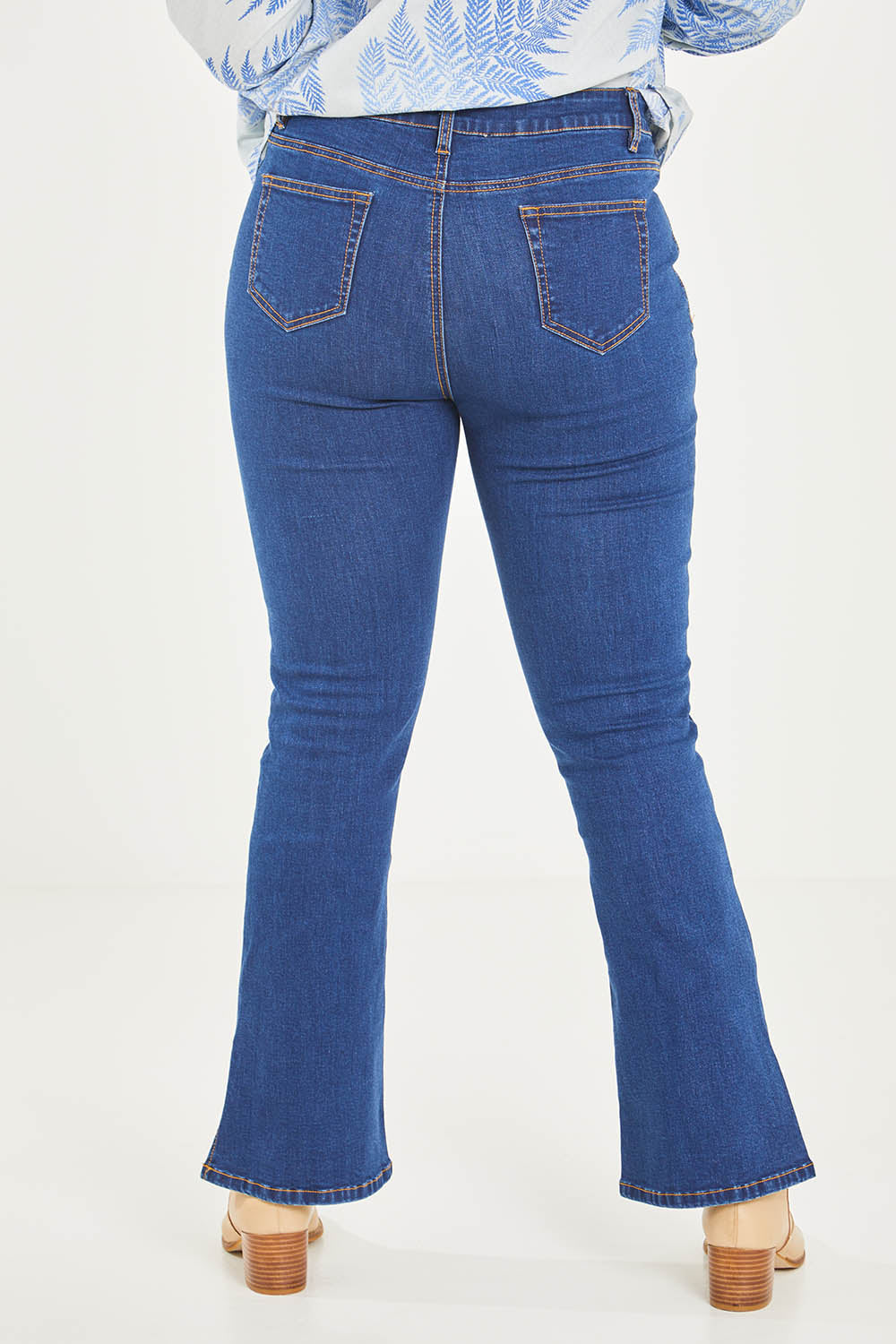 Model Noli wearing size 14 of the Shaking My Tail Feather Flared Jeans in colour Indigo (Blue), from the back