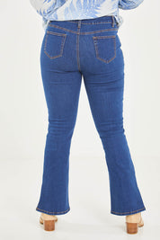 Model Noli wearing size 14 of the Shaking My Tail Feather Flared Jeans in colour Indigo (Blue), from the back