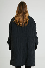 Model Laura wearing size 14 of the Heart Warming Quilted Anorak in colour Black (Black), from the back