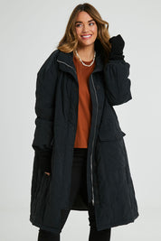 Model Laura wearing size 14 of the Heart Warming Quilted Anorak in colour Black (Black), from the front, cropped image