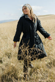 Model Tegan wearing size 10 of the Heart Warming Quilted Anorak in colour Black (Black), from the front, showing the whole outfit