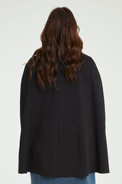 Model Laura wearing size 14 of the Sherlock And I Ponte Cape in colour Black (Black), from the back