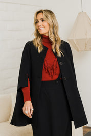 Model Tegan wearing size 10 of the Sherlock And I Ponte Cape in colour Black (Black), from the front, showing the whole outfit
