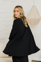 Model Tegan wearing size 10 of the Sherlock And I Ponte Cape in colour Black (Black), from the front, showing the whole outfit