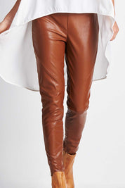 Model Clementine wearing size 8 of the My Trusty Steed Pants in colour Saddle, from the front, cropped image