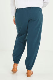 Model Terri-Leigh wearing size 14 of the Dawn Break Relaxed Pants in colour Ocean (Blue), from the back