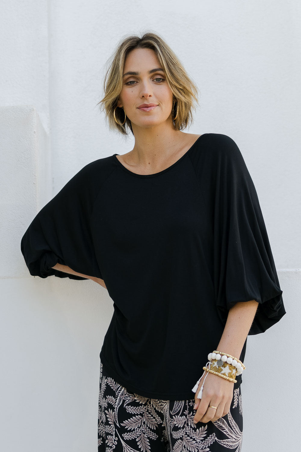 Model Tegan wearing size 10 of the Softly Swinging Balloon Sleeve Tee in colour Black (Black), from the front, cropped image