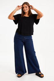 Model Monique wearing size 14 of the Short And Sweet Bamboo Layered Tee in colour Black (Black), from the front, showing the whole outfit