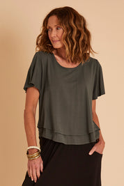 Model Emma wearing size 10 of the Short And Sweet Bamboo Layered Tee in colour Combat (Green), from the front, cropped image