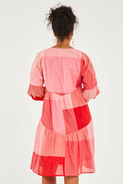 Model Noli wearing size 14 of the Twirl Worthy Cotton Tiered Dress in colour Redpink (Pink), from the back