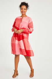Model Noli wearing size 14 of the Twirl Worthy Cotton Tiered Dress in colour Redpink (Pink), from the front, showing the whole outfit