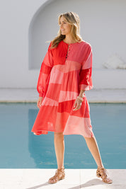 Model Tegan wearing size 10 of the Twirl Worthy Cotton Tiered Dress in colour Redpink (Pink), from the front, showing the whole outfit