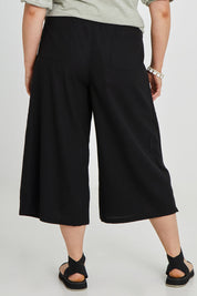 Model Keeara wearing size 16 of the Thats A Wrap Front Pants in colour Black (Black), from the back