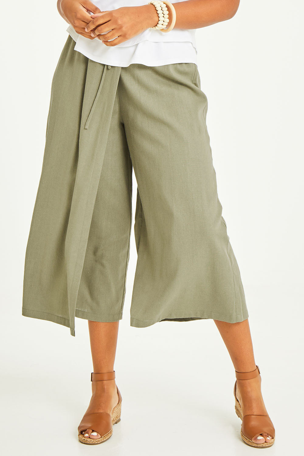 Model Noli wearing size 14 of the Thats A Wrap Front Pants in colour Khaki (Green), from the front, cropped image