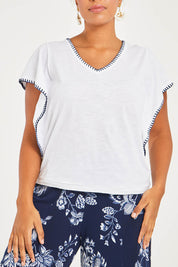 Model Noli wearing size 14 of the Blanket Stitch Butterfly Top in colour White (White), from the front, cropped image