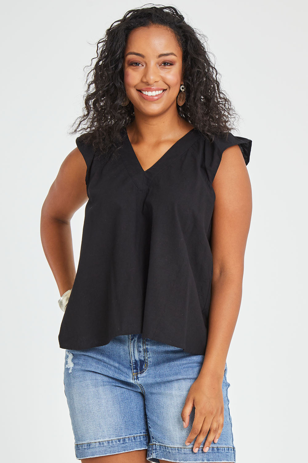 Model Noli wearing size 14 of the Frill Me Cotton Top in colour Black (Black), from the front, cropped image