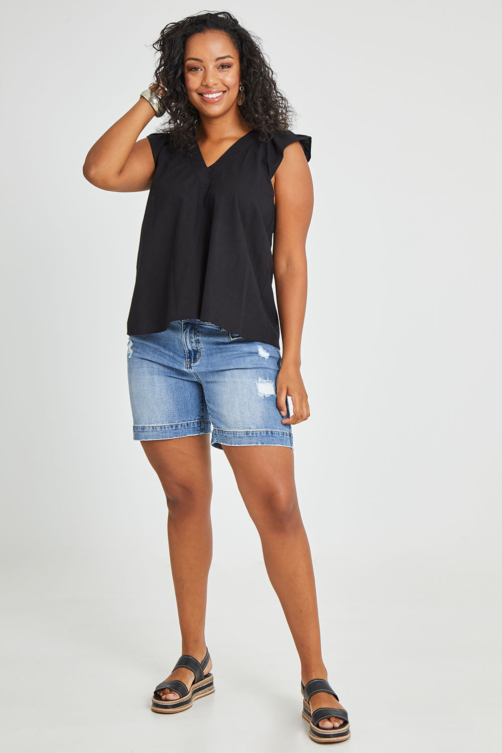 Model Noli wearing size 14 of the Frill Me Cotton Top in colour Black (Black), from the front, showing the whole outfit