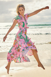 Model Tegan wearing size 10 of the Thats A Wrap Printed Cotton Dress in colour Pinkgarden (Pink), from the front, showing the whole outfit