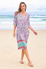 Model Tegan wearing size 10 of the Sunshine And Flowers Smock Dress in colour Aquafleur (Blue), from the front, showing the whole outfit