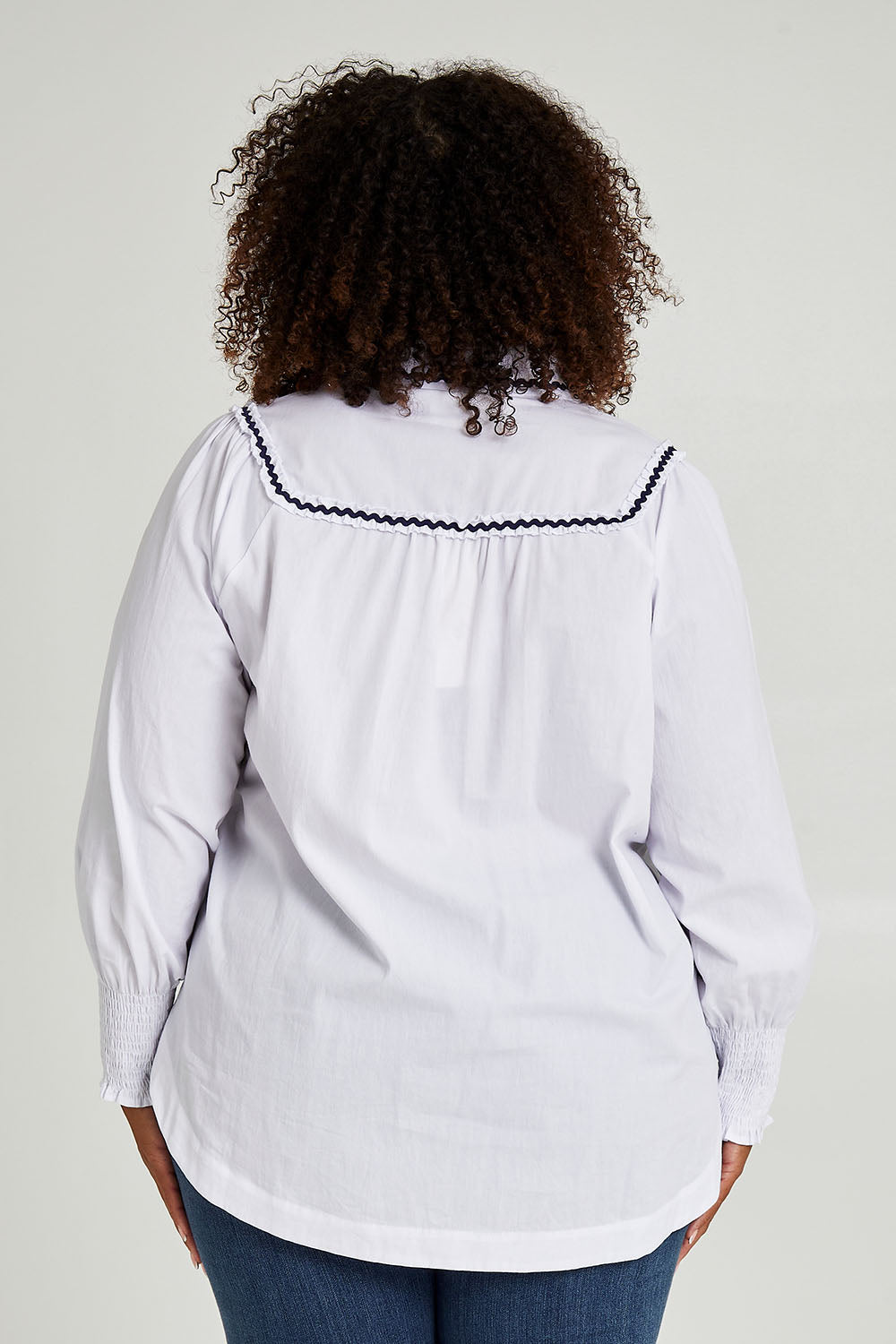 Model Alexis wearing size 16 of the Ric Rac Romance Blouse in colour White (White), from the back