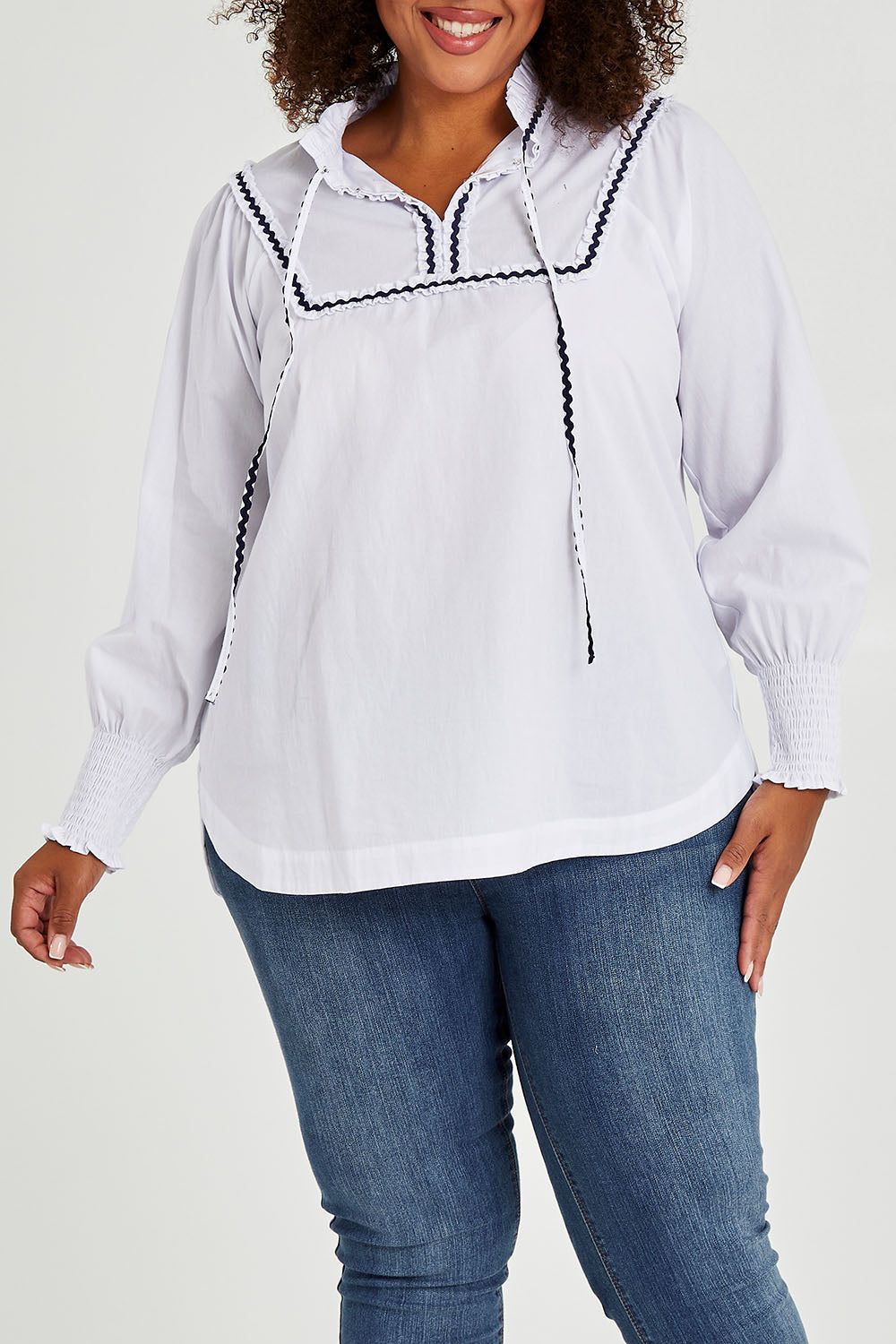 Model Alexis wearing size 16 of the Ric Rac Romance Blouse in colour White (White), from the front, cropped image