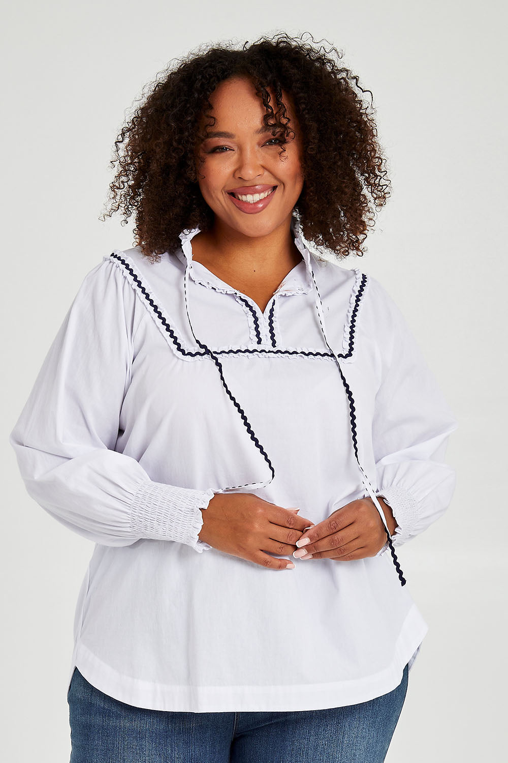 Model Alexis wearing size 16 of the Ric Rac Romance Blouse in colour White (White), from the front, cropped image