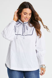 Model Laura wearing size 14 of the Ric Rac Romance Blouse in colour White (White), from the front, cropped image