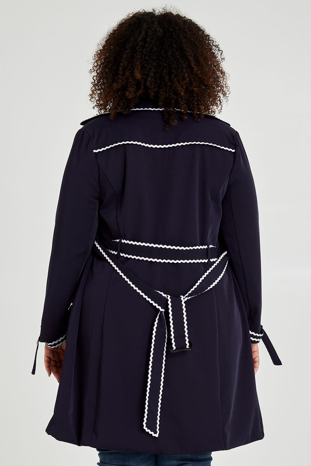 Model Alexis wearing size 16 of the Forever In Style Trench Coat in colour Navy (Blue), from the back