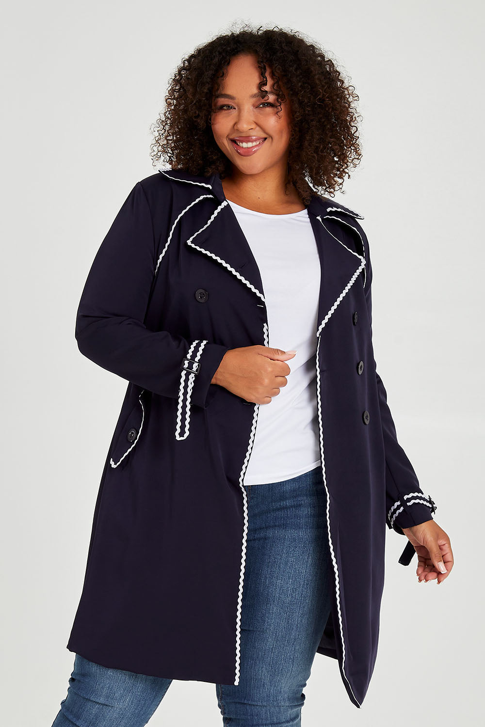 Model Alexis wearing size 16 of the Forever In Style Trench Coat in colour Navy (Blue), from the front, cropped image