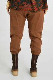 Model Laura wearing size 14 of the Brunch and Dinner Tencel Pants in colour Rust, from the back