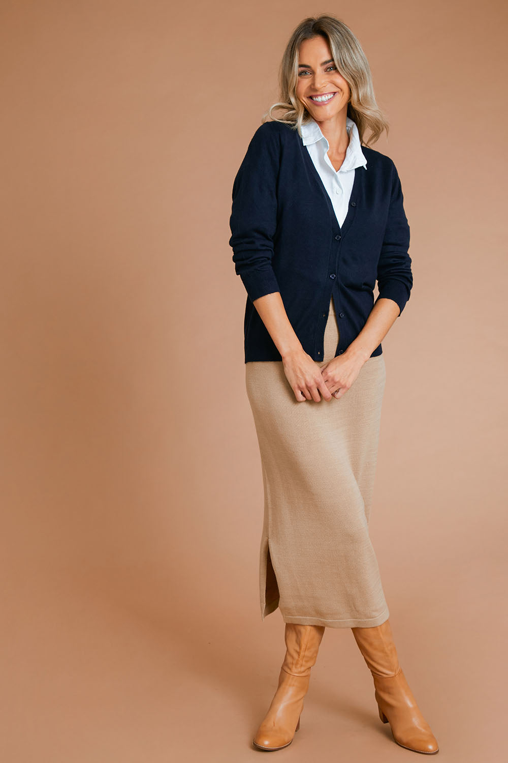 Model Alice wearing size S of the Knit Pick Pull On Skirt in colour Sand, from the front, showing the whole outfit