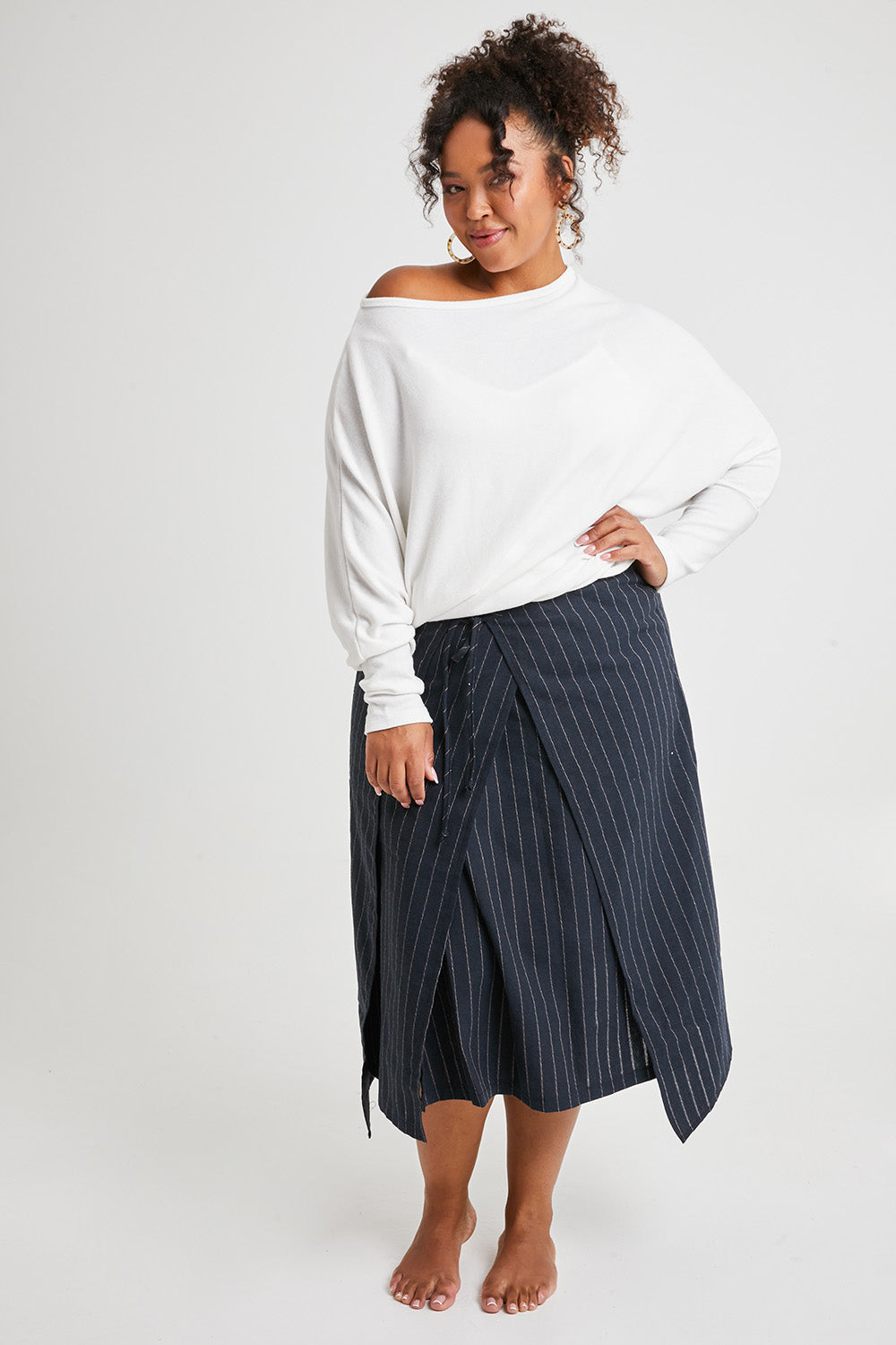 Model Alexis wearing size 16 of the Sweet Delight Apron Wrap Skirt in colour Blkstripe (Black), from the front, showing the whole outfit