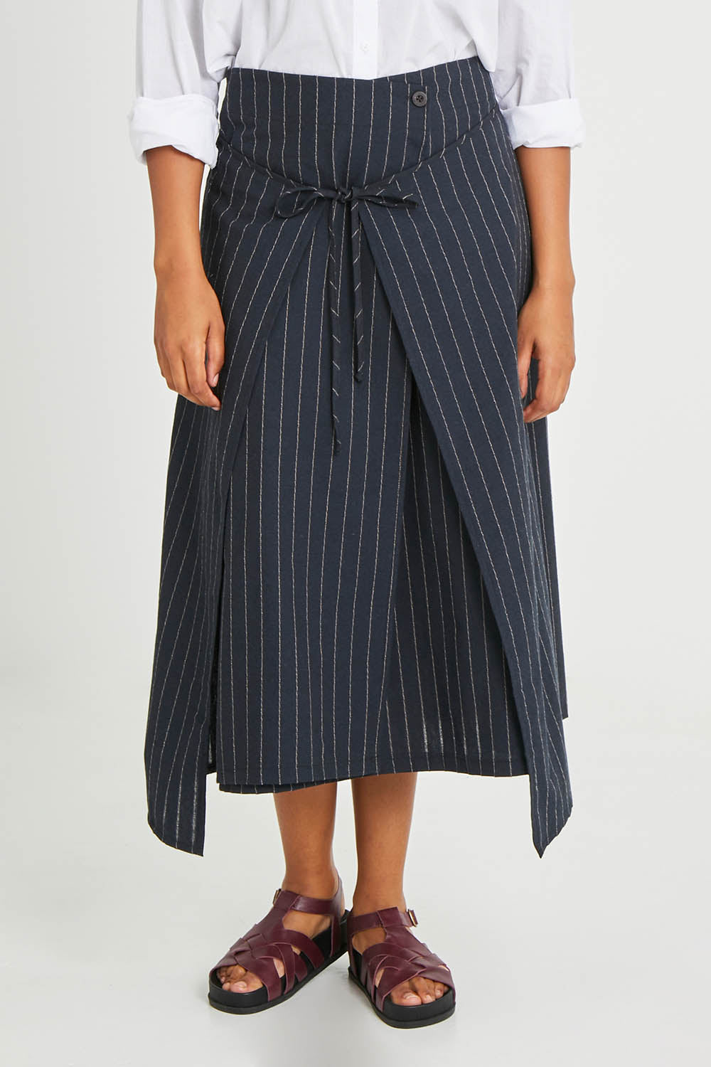 Model Noli wearing size 14 of the Sweet Delight Apron Wrap Skirt in colour Blkstripe (Black), from the front, cropped image