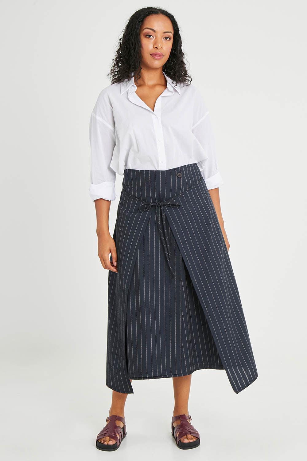 Model Noli wearing size 14 of the Sweet Delight Apron Wrap Skirt in colour Blkstripe (Black), from the front, showing the whole outfit