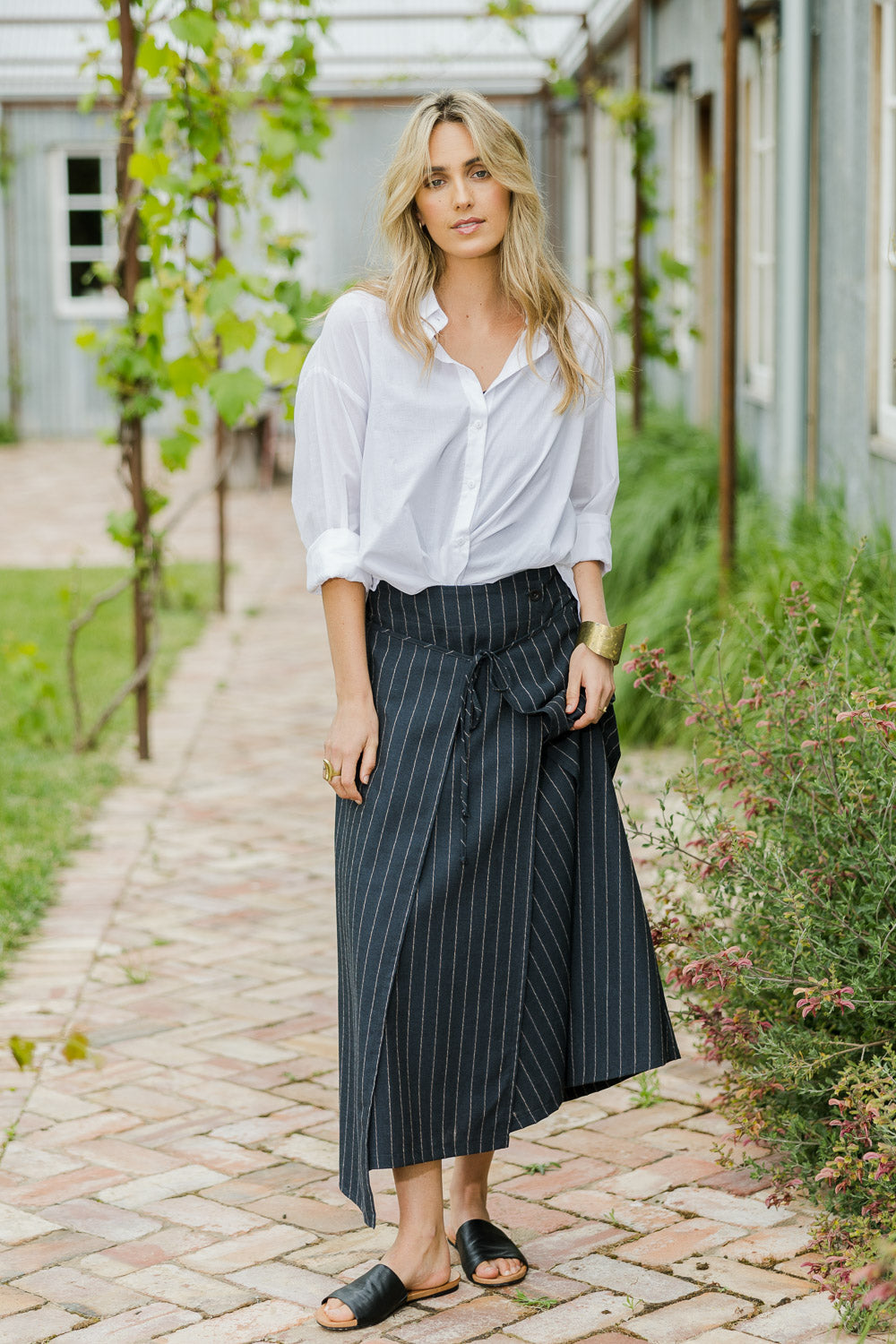 Model Tegan wearing size 10 of the Sweet Delight Apron Wrap Skirt in colour Blkstripe (Black), from the front, showing the whole outfit