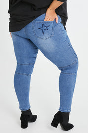 Model Alexis wearing size 16 of the Wild Plains Flat Front Stitch Jeggings in colour Denim (Blue), from the back