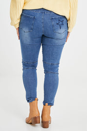 Model Laura wearing size 14 of the Wild Plains Flat Front Stitch Jeggings in colour Denim (Blue), from the back