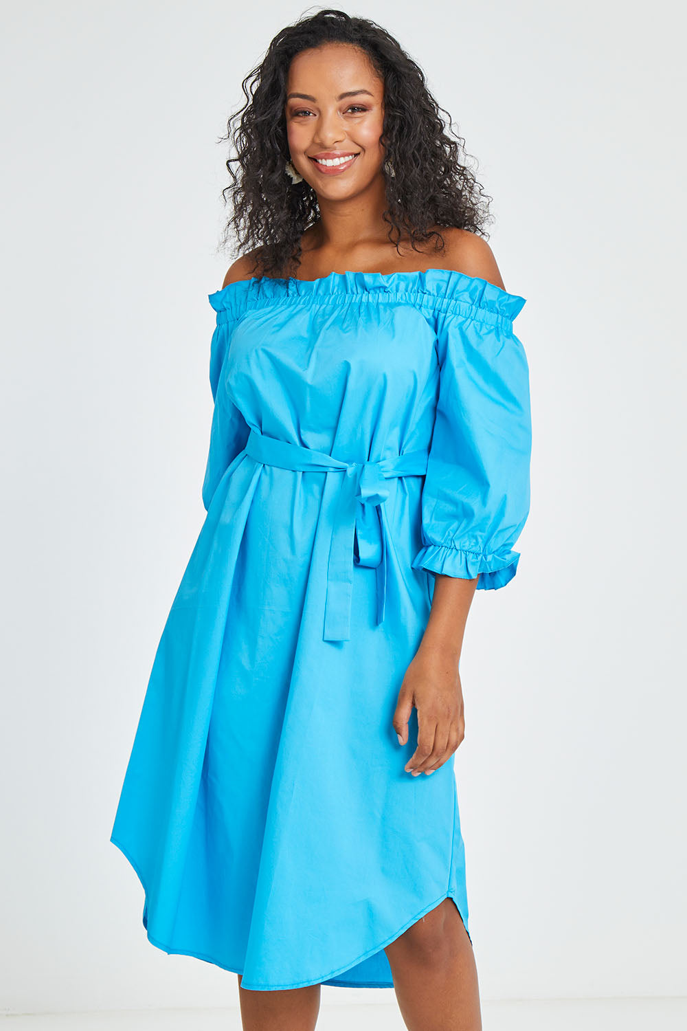 Model Noli wearing size 14 of the Good Vibes Off Shoulder Cotton Dress in colour Bluerad (Blue), from the front, cropped image