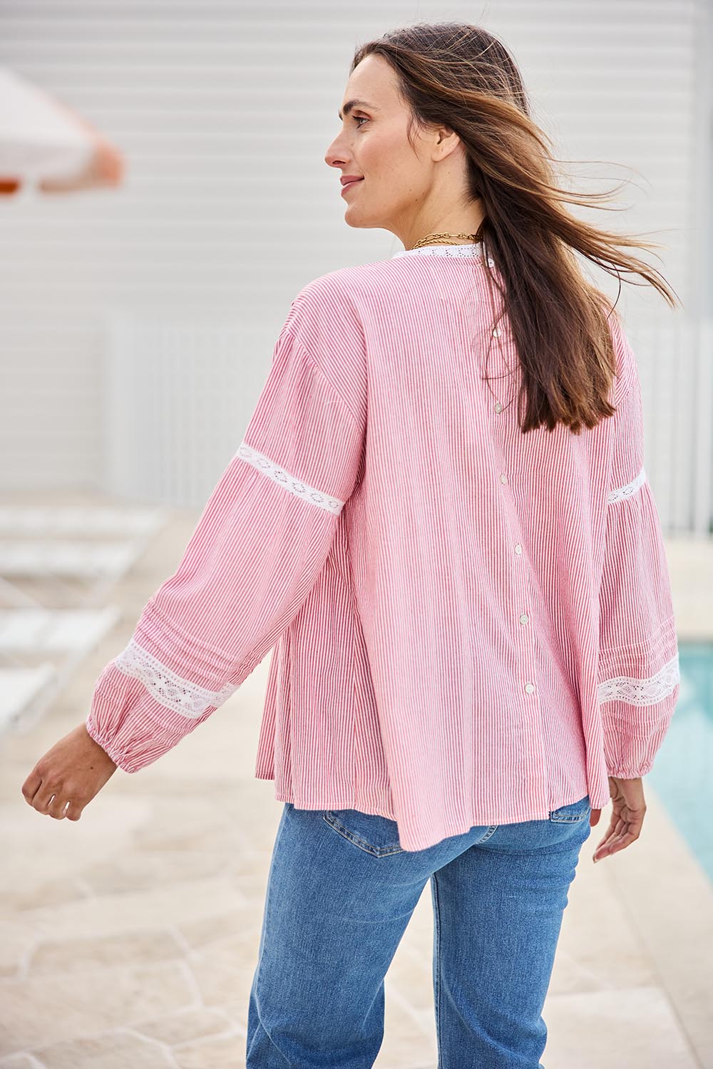 Model Tegand wearing size 10 of the At My Best Button Back Blouse – Redstripe in colour Redstripe, from an angle