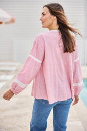 Model Tegand wearing size 10 of the At My Best Button Back Blouse – Redstripe in colour Redstripe, from an angle