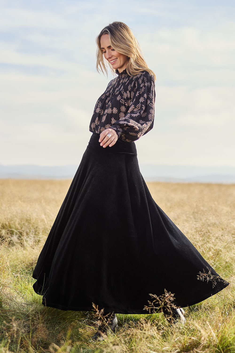 Model Tegan wearing size 10 of the Love By Candlelight Velvet Skirt in colour Black (Black), from the front, showing the whole outfit