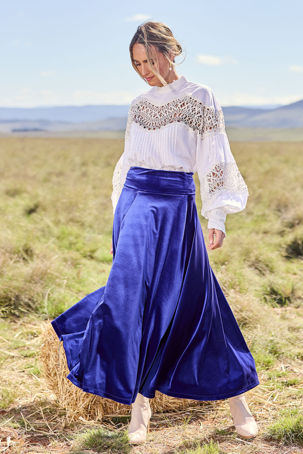 Model Tegan wearing size 10 of the Love By Candlelight Velvet Skirt in colour Sapphire (Blue), from the front, showing the whole outfit