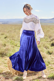 Model Tegan wearing size 10 of the Love By Candlelight Velvet Skirt in colour Sapphire (Blue), from the front, showing the whole outfit